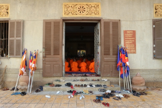 Wat Ounalum. Ceremonia budista. Los monjes se quitan sus zapatos para entrar en el templo.